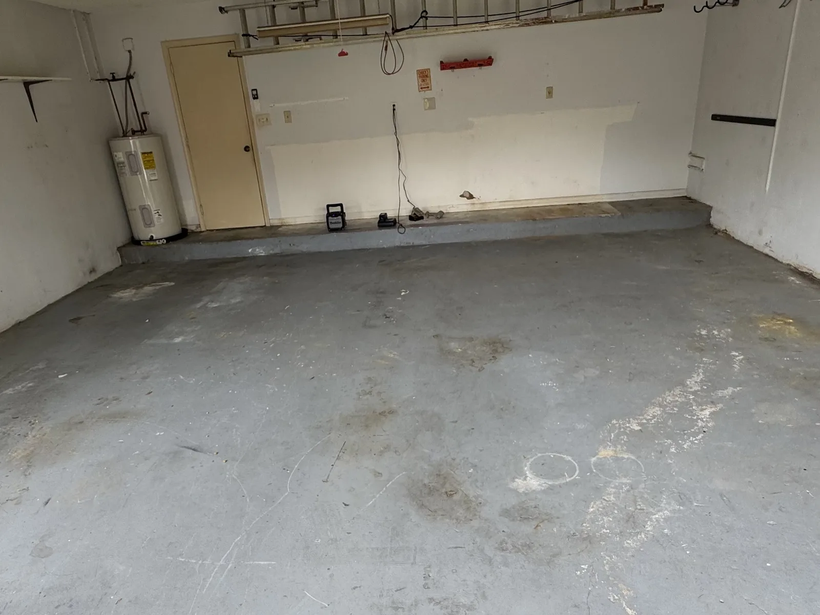Worn stained garage floor before epoxy installation