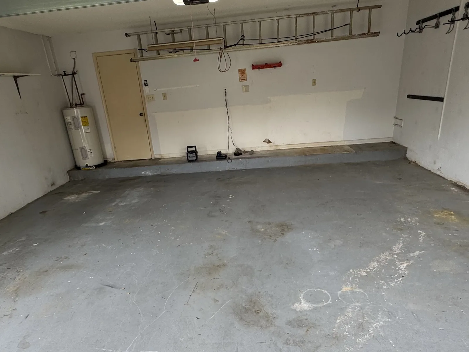 Worn bare concrete garage floor before storm grey flake system